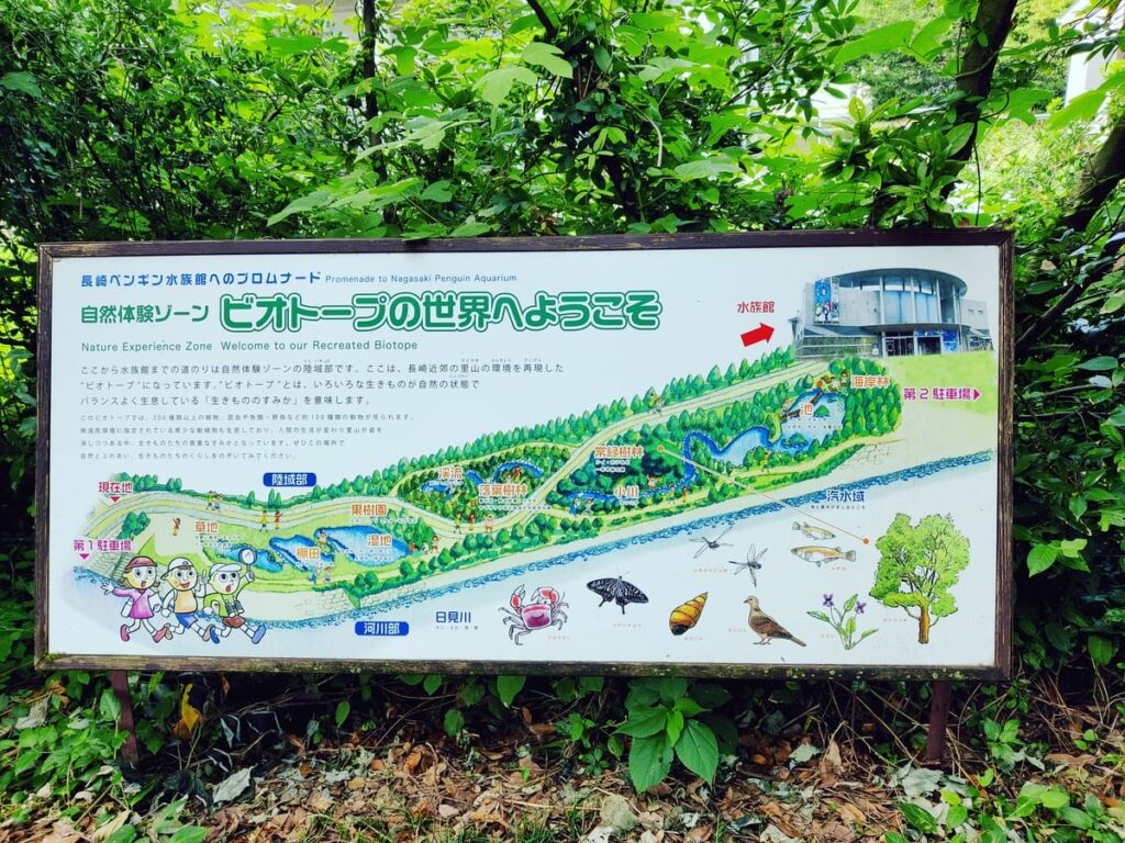 large sign with biotope information and map of paths and zones. "Nature Experience Zone. Welcome to our Recreated Biotope." 自然体験ゾーン。ビオトープの世界へようこそ。