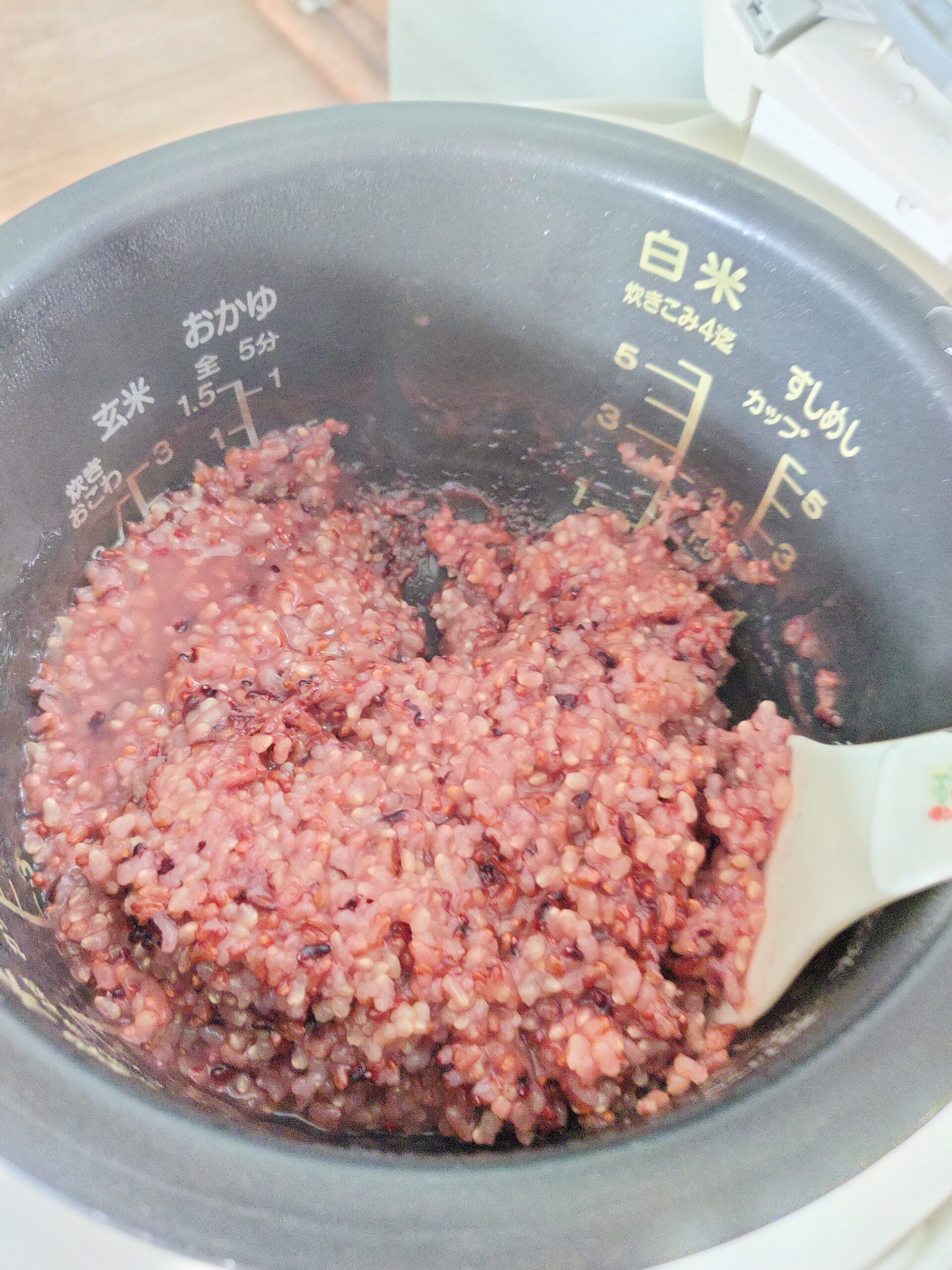 reddish-pink colour sticky cooked ancient rice in rice cooker pot.